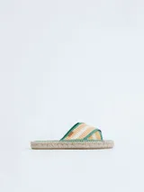Sandalias tipo alpargata con suela de yute trenzado y tiras cruzadas en tejido de lino a rayas en tonos beige y blanco, con bordes en color verde.