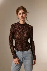 Top de manga larga con cuello alto, confeccionado en tejido semitransparente con estampado tipo paisley en relieve.