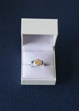 Anillo de plata con aplique de cruz en oro en el centro.