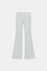 Pantalón flare stretch negro de tiro medio, con cintura elástica y botamanga acampanada.