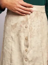 Falda mini color verde esmeralda, de corte recto con cierre frontal de botones.