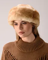 Gorro tipo ushanka de piel sintética en tono beige con textura suave y voluminosa.