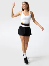 Top deportivo blanco de escote redondo con tirantes anchos y diseño ajustado.