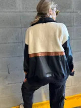 Campera negra con paneles de cuero sintético con textura de cocodrilo, corderito color crema en la parte superior y detalles en cuero marrón.