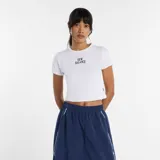 Remera de algodón blanca con cuello redondo y mangas cortas, corte ajustado al cuerpo y logo de New Balance bordado en el centro del pecho.