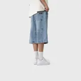 Bermuda baggy de denim color celeste, corte holgado y diseño con costuras frontales diagonales.