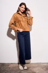 Camisa color camel de gamuza sintética, corte al cuerpo, con flecos en el pecho y mangas largas.