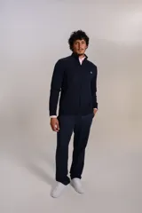 Cardigan de punto color azul marino, con cuello alto, cierre frontal completo y puños acanalados. Presenta el logo de la marca bordado en el pecho.