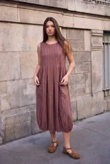 Vestido midi sin mangas, con diseño a rayas en tonos marrón y azul, cuello redondo y bolsillos laterales amplios.