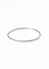 Pulsera esclava rígida de acero quirúrgico color plateado, con corazones grabados.