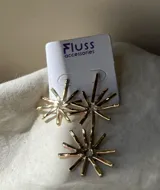 Par de aros colgantes de metal dorado con forma de sol. Cada aro tiene dos soles, uno más pequeño arriba y otro más grande abajo.