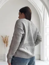 Saco de lana color gris con textura tejida y botones marrones.