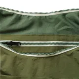 Bolso tipo hobo color verde oliva, con correa larga para llevar al hombro y bolsillo externo.