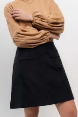 Minifalda negra de velvetine con spandex y bolsillos frontales.