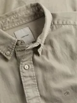 Camisa de manga larga Calvin Klein, confeccionada en sarga de algodón. Presenta cuello abotonado, cierre frontal con botones y logo de la marca bordado en el pecho.