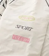 Campera bomber de microfibra color beige con estampado frontal de lettering 'PARIS 1985'. Presenta cierre frontal con cremallera, cuello alto, bolsillos funcionales y puños y ruedo ajustados con elástico.