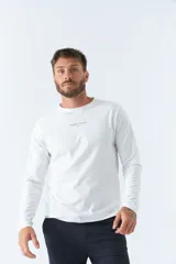 Remera básica de hombre color blanco, de manga larga y escote redondo, con logo y arte estampado en el pecho que dice "NEVER STOP EXPLORING Established in Torino, Italy. Since 1971".