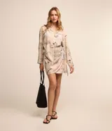 Pollera recta corta de viscosa en color beige con estampado de paisajes y palmeras, con lazo lateral ajustable en la cintura.