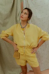 Campera tipo bomber de lino color amarillo, con cierre frontal metálico y mangas largas con puños elásticos.