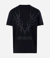 Remera masculina de algodón negro con cuello redondo, mangas cortas y corte comfort. Presenta un estampado tribal sutil en el centro del pecho.