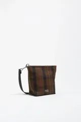 Bolso bandolera de gabardina con estampado de cuadros en tonos marrones y verdes, con asa de cinta negra regulable y logo de la marca estampado en la parte inferior.