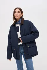 Campera de gabardina azul marino con cuello de pana marrón, interior capitoneado, cierre frontal con cremallera y botones a presión, y bolsillos frontales con solapa.