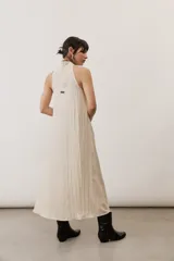 Vestido largo marrón, sin mangas, con cuello halter y bolsillos laterales.