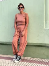 Conjunto de dos piezas compuesto por un top sin mangas de cuello redondo y un pantalón tipo babucha cargo con bolsillos laterales y puños elásticos en los tobillos.