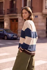 Sweater de tejido de punto oversize con diseño de rayas horizontales en tonos beige, azul marino y marrón, cuello redondo y mangas largas.