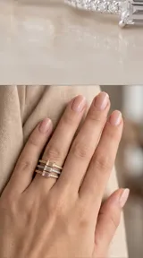Anillo triple compuesto por tres bandas finas con baño de oro y oro rosa, cada una decorada con una circonia en corte rectangular.