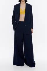 Blazer azul marino de viscosa con escote y solapas, manga larga, cierre frontal con botonadura y bolsillos de plastrón en el delantero.