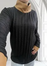 Polera negra de tejido trenzado con cuello alto y puños de cuero color camel.