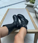Bota de caña alta confeccionada en cuero vacuno encerado, con diseño de estilo biker. Presenta detalles de hebillas metálicas niqueladas en la caña y cierre lateral. Cuenta con suela de cuero artesanal y forrería vacuna en su interior.
