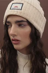 Gorro de punto fucsia con etiqueta de marca en el frente.