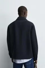 Chaquetón de corte regular fit, con cuello solapa, manga larga y cierre frontal con botones. Presenta dos bolsillos de plastrón con solapa en la parte frontal y un bolsillo interior.