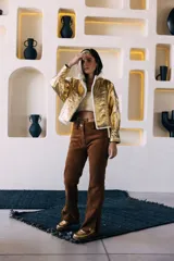 Campera oversize de cuero tostado con solapas y forro interno de corderito sintético azul marino, mangas anchas y detalles de costuras trenzadas.