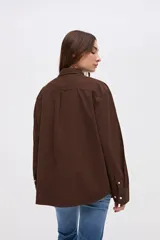 Sobrecamisa de algodón color marrón, con cuello solapa, cierre frontal de botones y bolsillos frontales en el pecho.
