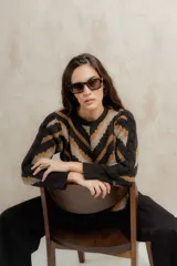 Sweater de punto jacquard con diseño de chevron en tonos celeste y marrón. Presenta cuello redondo, corte holgado y mangas largas con hombros abullonados.