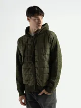 Campera verde militar con capucha, cierre frontal y mangas largas de punto con textura. El cuerpo es capitoneado con diseño de rombos.