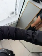 Top negro de manga larga con escote tipo bardot y detalles de encaje en el borde del escote y en los puños acampanados.