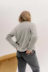 Saco tejido de lana con diseño de ochos y aranes en el frente. Presenta cierre frontal con ganchos peleteros, cuello redondo y pin bordado de la marca en la parte inferior.