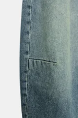 Jeans de tiro medio y corte balloon color azul, con trabillas, bolsillos delanteros y traseros, y cierre frontal con cremallera y botón metálico.