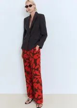 Pantalón largo de corte recto con estampado floral en tonos rojo y marrón, cuenta con cintura elástica y bolsillos laterales.