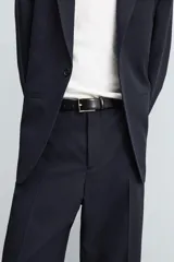 Pantalón de corte recto confeccionado en tejido con lana, color beige. Presenta bolsillos frontales, bolsillos traseros de vivo y cierre frontal con cremallera y botón.