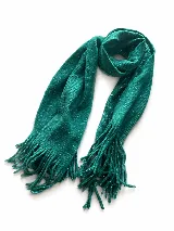 Bufanda de tejido suave con diseño a cuadros en tonos blanco, gris y negro, con flecos en los extremos.