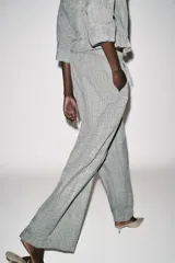 Pantalón de tiro alto color gris jaspeado, con cintura elástica y pernera ancha.