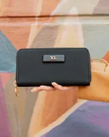 Billetera XL Extra Large modelo Celeste Fichero, color negro con textura geométrica, cierre perimetral y aplicación frontal con el logo de la marca en herraje dorado.