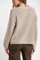 Sweater de punto texturado en color bordó con destellos de lurex, de corte holgado, cuello redondo y mangas largas.