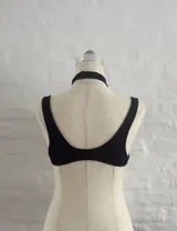 Body negro con escote halter cruzado y abertura en el abdomen.