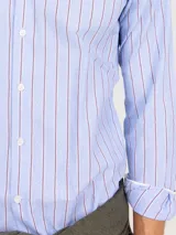 Camisa de manga larga confeccionada en algodón, con diseño de rayas verticales en tonos celeste y bordó. Presenta cuello italiano, cierre frontal con botones y logo bordado en el pecho.